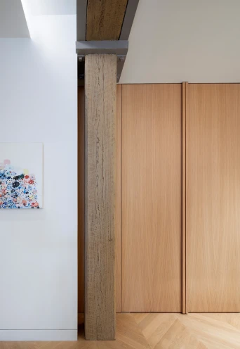 Entrance vestibule, with custom oak wood cabinetry , chevron pattern wood flooring and refinished old wood beam &amp; column reminiscent of the original wood structure of the building.
