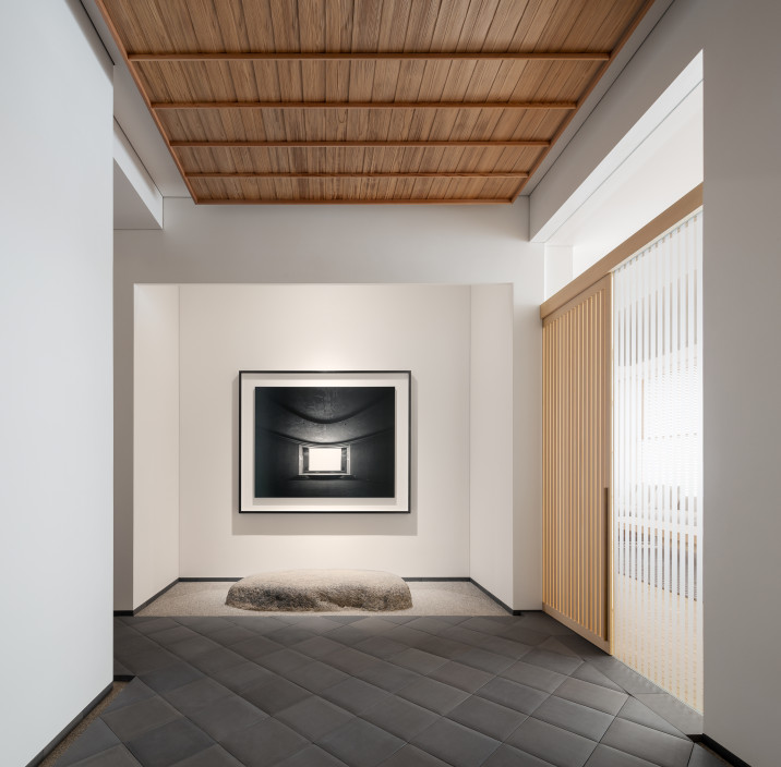 Detail view of main corridor art niche with a photograph by Hiroshi Sugimoto. Custom dark gray diagonal tile flooring and custom wood ceiling, with all walls clad with shikkui plaster.