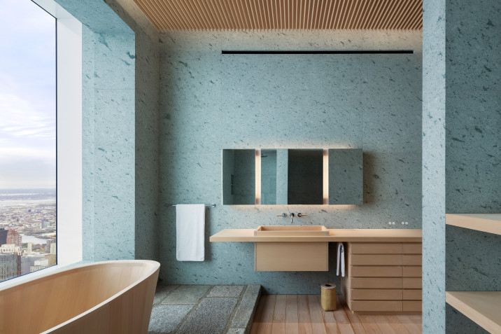 Bathroom view, with traditional Japanese wooden bath tub, raised recycled stone paver platform, green tuff stone clad walls, and custom cedar wood bathroom cabinetry.