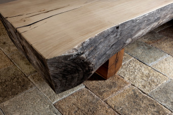 Detail view of 45R's new clothing store in Soho, New York, showing a merchandise display table made of a very thick solid slab of wood with live-edge.