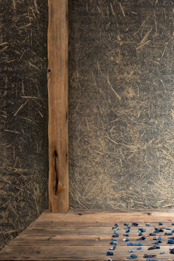 Detail view of the tokonoma niche at 45R's new clothing store in Soho, New York, showing recycled wood and a straw-embedded mud wall finish.