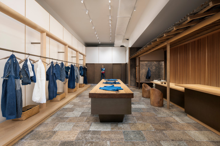 Overall view of 45R's new clothing store in Soho, New York, with clothing display rackets, display tables and bronze-clad customer service counter.